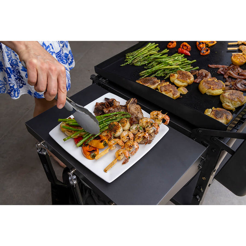 Louisiana Grills 4-Burner Gas Griddle with Ceramic Top. cooking shrimp and veggies on the griddle and plating food