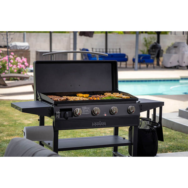 Louisiana Grills 4-Burner Gas Griddle with Ceramic Top. Cooking food in backyard near pool